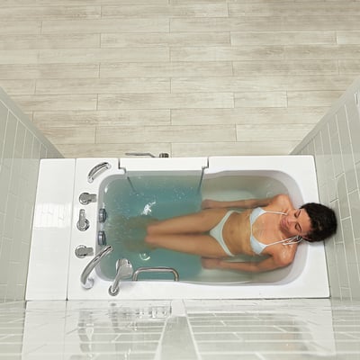 Woman relaxing with eyes closed in the Ella Monaco walk-in tub with outward swing door and hydro jets active