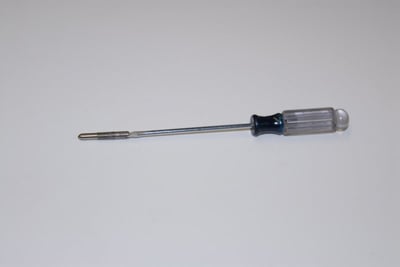 Outil taraudé avec poignée transparente et bleue, utilisé pour l’installation de la vis à pied réglable du drain de plancher de baignoire à porte