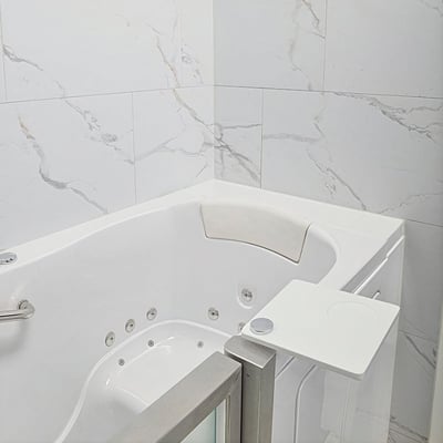 Interior de bañera de hidromasaje Ella con hidromasaje, almohada cervical, bandeja giratoria y paneles de pared sin lechada con aspecto de mármol Carrara