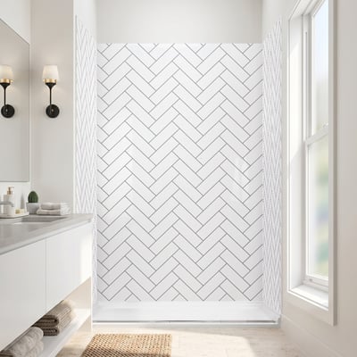 Sunlit walk in shower with herringbone acrylic wall panels, white shower pan and a woven bath mat