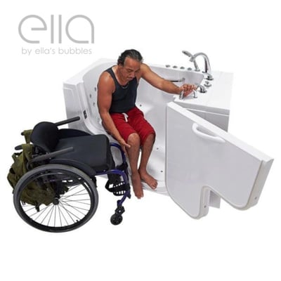 Wheelchair user transferring independently into an Ella walk-in tub with open outswing door beside his wheelchair