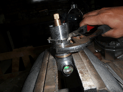 Technicien utilisant une clé à molette pour retirer une vanne d’inverseur de baignoire à porte lors d’une réparation ou d’une installation de plomberie
