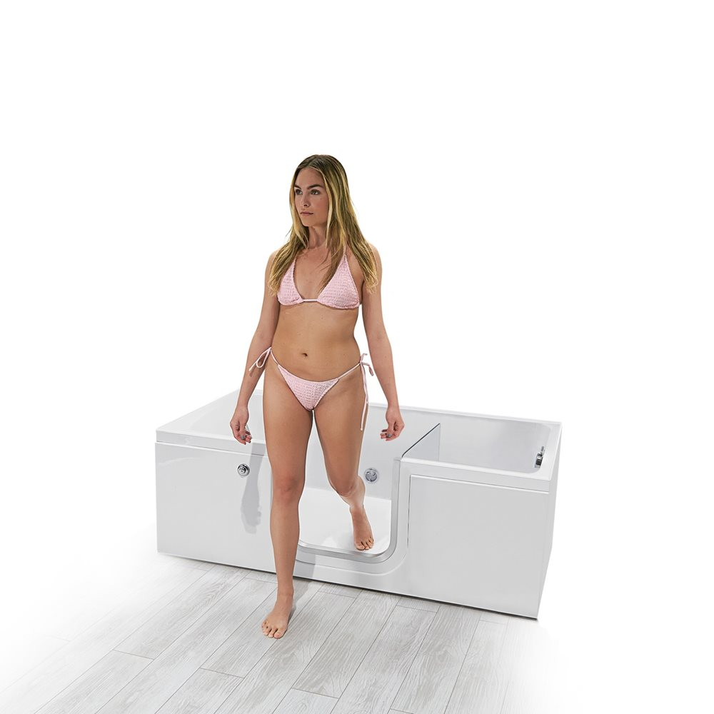 Woman stepping out through the low-step inward swing door of an Ella LayDown60 walk-in bathtub