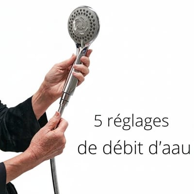 Mains d’une personne âgée tenant une douchette chromée à flexible avec 5 réglages de débit d’eau