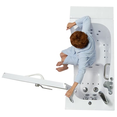 Overhead view of a senior woman in a blue robe transferring into an Ella Transfer 26 ADA accessible walk-in bathtub with outward swing door