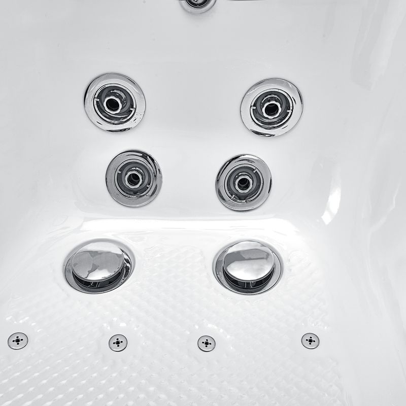 Primer plano de los chorros cromados de hidromasaje, los chorros para los pies y el suelo antideslizante dentro de una bañera con puerta Ella