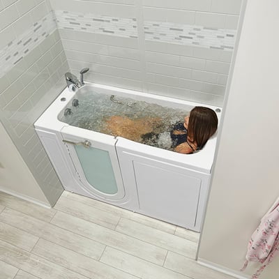 Femme se relaxant lors d’une séance d’hydrothérapie active dans une baignoire à porte Ella avec porte à ouverture extérieure