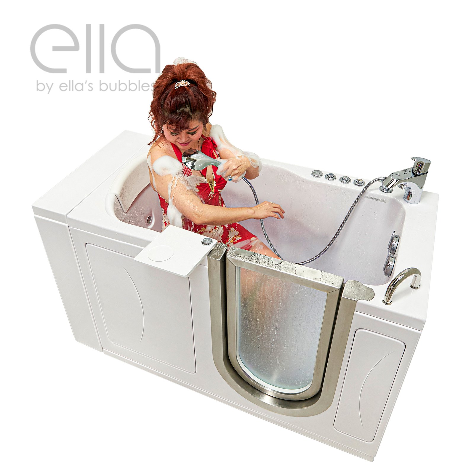 Woman in red dress using handheld showerhead while seated inside the Ella Petite 28x52 walk-in tub with open door