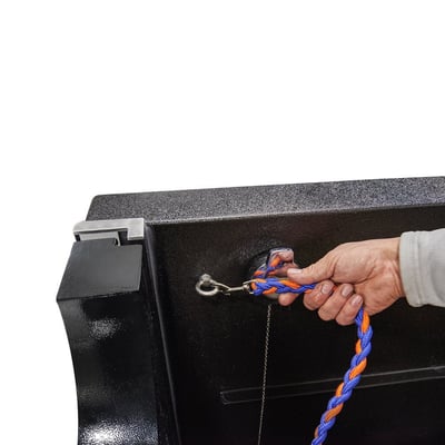 Close-up of a hand pulling a braided rope handle attached to the door latch of a black pet spa walk-in tub