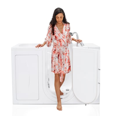 Woman stepping into the Ella Capri walk in tub through its wide open outward swing door with glass viewing panel