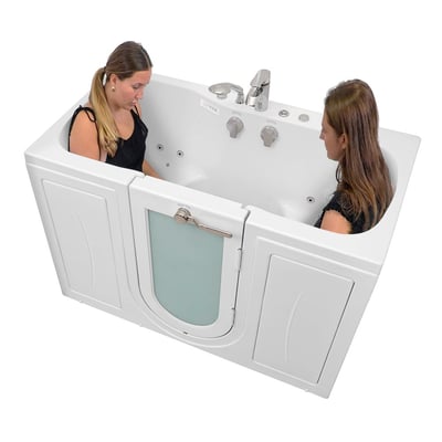 Two women sitting facing each other inside the Ella Tub4Two 2-seat walk-in tub with outward swing frosted door and hydro jets