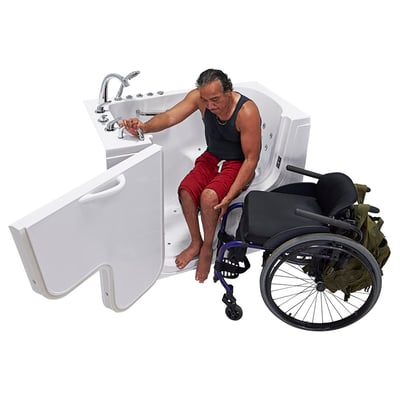Wheelchair user transferring from blue wheelchair into the Ella Transfer60 walk-in tub with outward swing door fully open