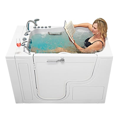 Woman reading a book while reclining in an Ella's Bubbles walk-in tub with the jets running and wine nearby