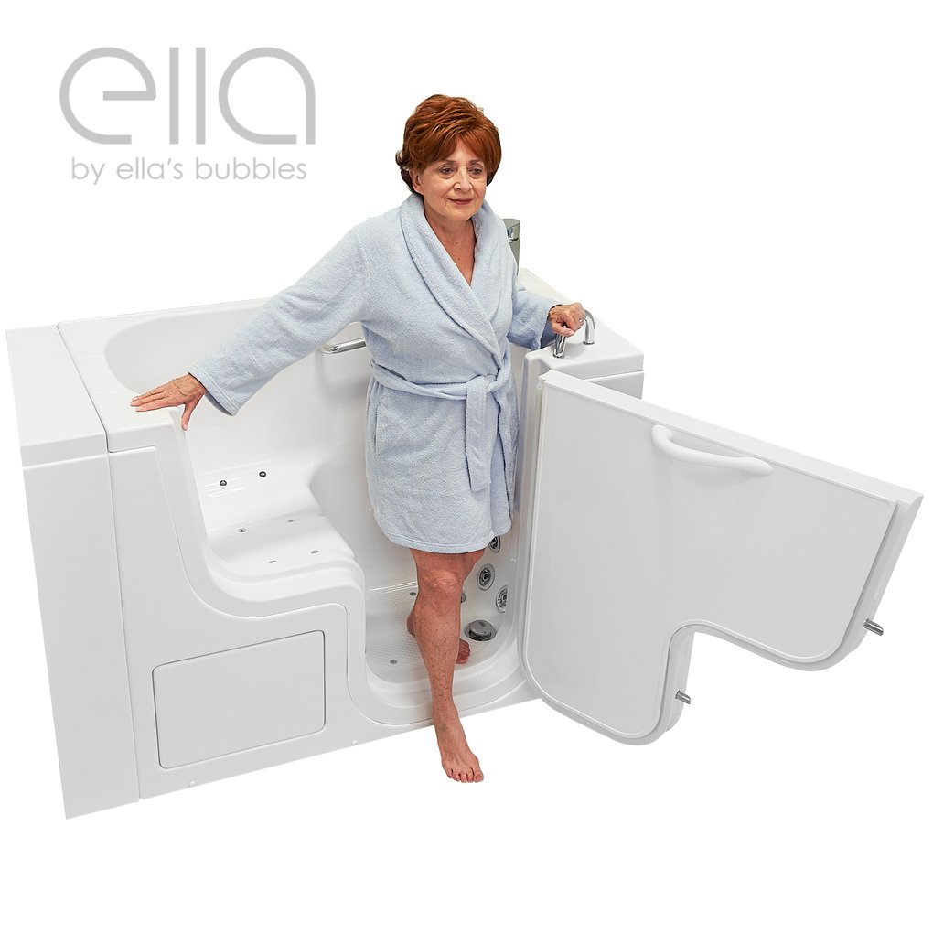 Senior woman in blue robe stepping into the Ella Transfer26 walk-in tub with open outswing door and grab bar