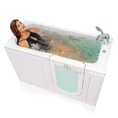 Femme allongée profitant d’un hydromassage dans la baignoire à porte Ella’s Bubbles Lounger avec double drain et robinet chromé