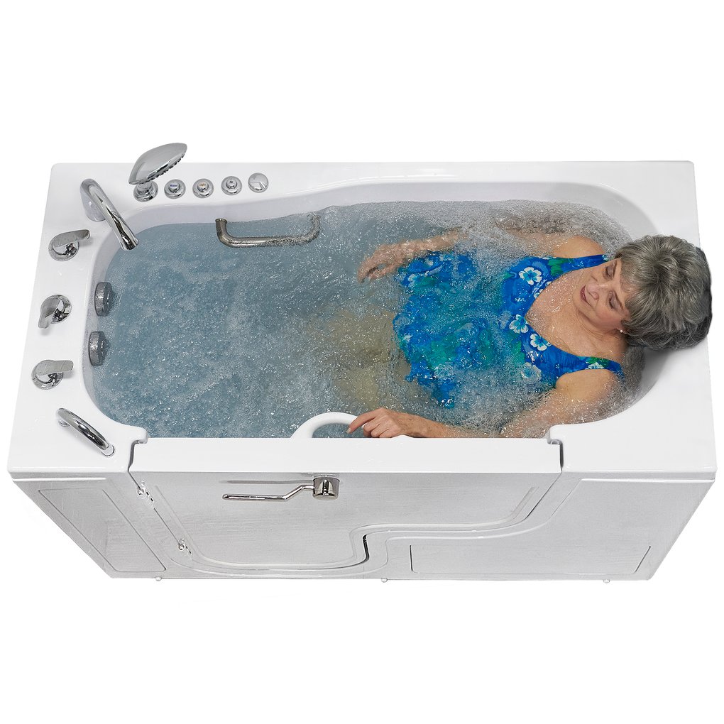 Woman reclining in a filled wheelchair transfer walk in tub with the hydrotherapy jets churning the water.
