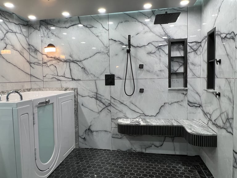 Luxury walk-in bathtub installation with marble walls, rain shower, built-in bench seat, and matte black fixtures