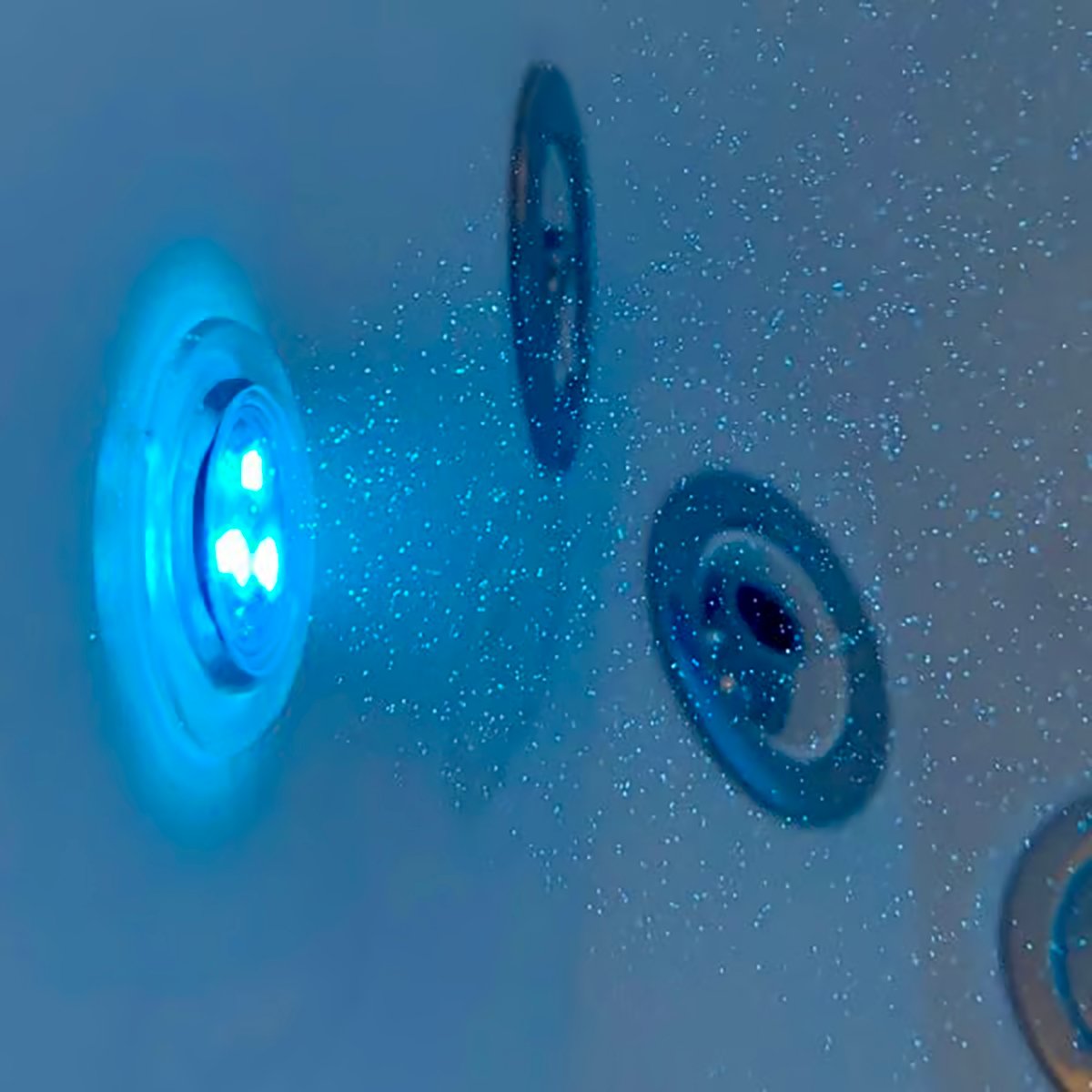 Glowing blue LED chromatherapy light and air jets on the interior wall of an Ella walk-in tub