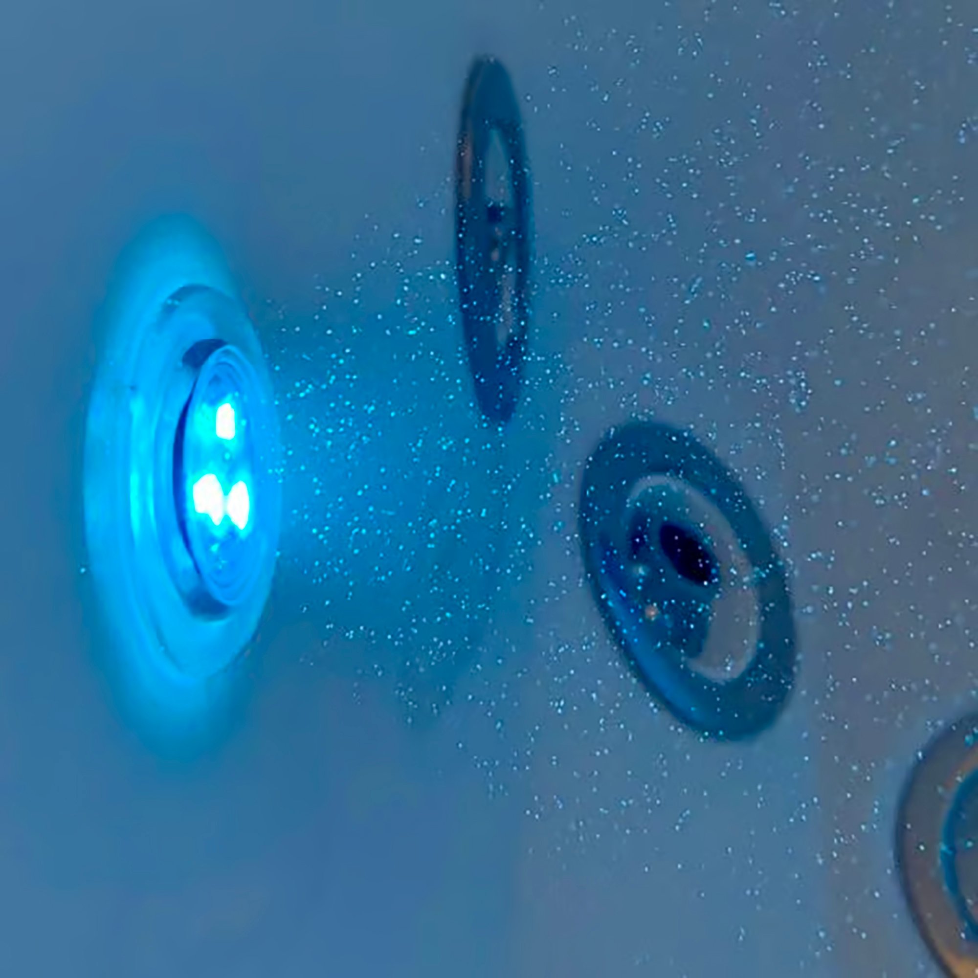 Glowing blue LED chromatherapy light and air jets on the interior wall of an Ella walk-in tub