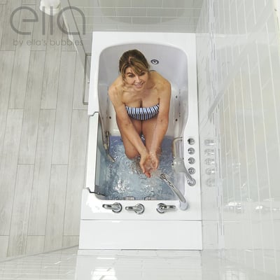 Woman smiling and splashing water in the Ella Ultra Acrylic walk-in tub with fast fill faucet and chrome dual drain controls