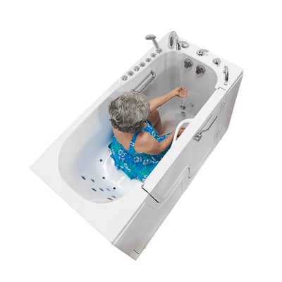 Senior woman seated in the Ella Transfer60 wheelchair accessible walk-in tub adjusting water flow with hydro jets active