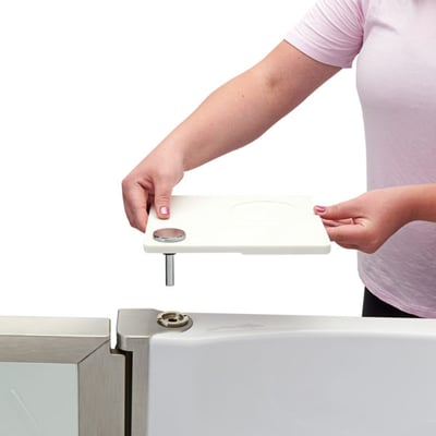 Woman installing the patented 360 swivel tray onto an Ella walk-in tub by aligning the tray post into the mount
