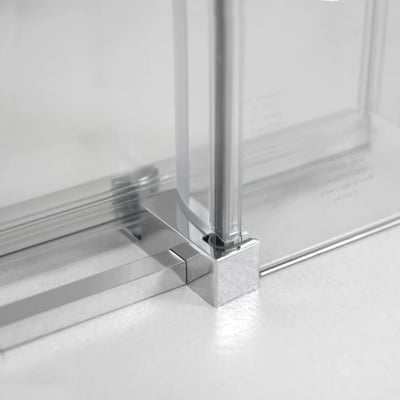 Primer plano de soporte de esquina cromado y umbral de perfil bajo en una puerta de ducha corredera de cristal templado de 8 mm