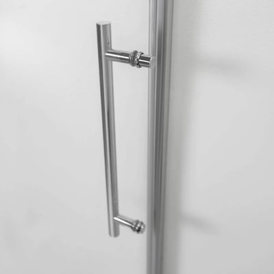 Primer plano de un tirador cromado pulido en un panel de puerta de ducha corredera de cristal templado de 8 mm