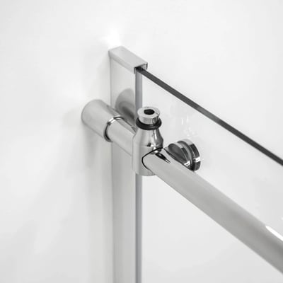 Primer plano de montaje de barra de apoyo cromado y conector de panel de cristal en un marco de puerta de ducha corredera accesible