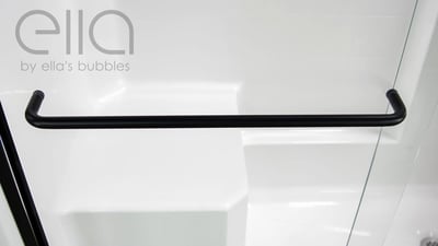 Gros plan d’une barre d’appui noir mat fixée sur le panneau en verre d’une cabine de douche accessible Ella avec parois en acrylique blanc