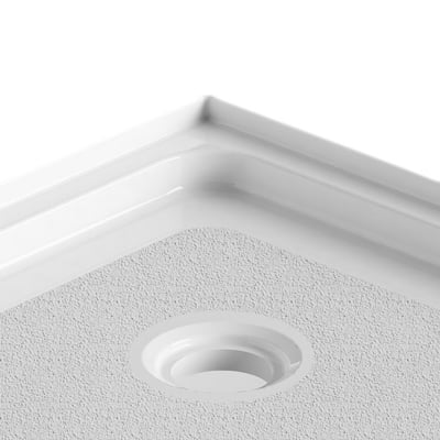 Close-up of the corner and center drain on a textured acrylic neo-round accessible shower base with raised edges