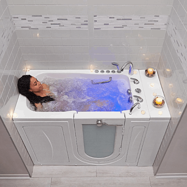 Woman relaxing in an Ella walk-in tub with blue chromatherapy lighting, illustrating walk-in tub financing and payment options