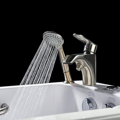 Close-up of brushed nickel handheld showerhead spraying water on an Ella walk-in tub with single-handle faucet