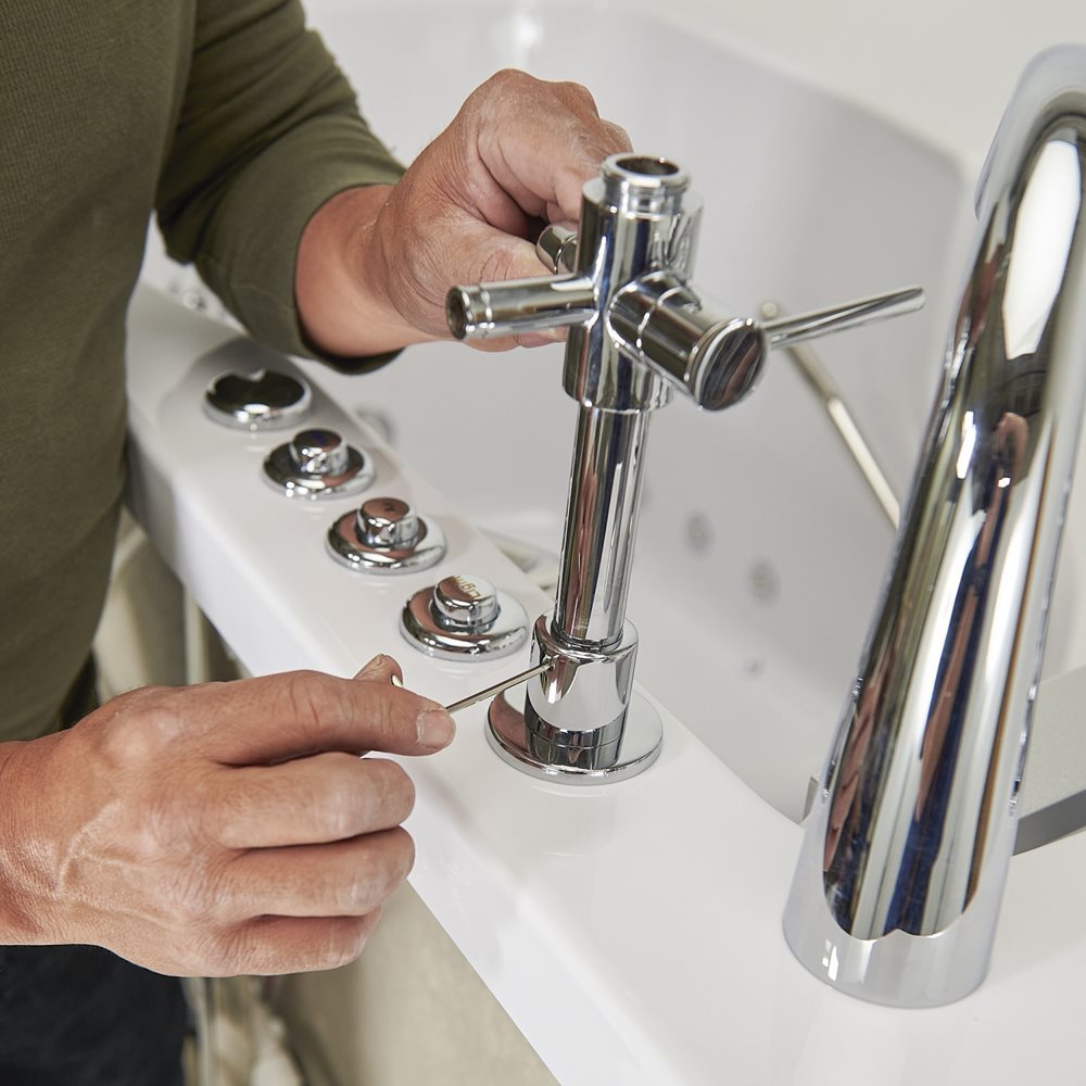 10″ Kit de tête de douche et colonne de douche pour robinets de baignoire encastrés dans le sol - Technician installing chrome cross-handle faucet and jet controls on the deck of an Ella walk-in tub