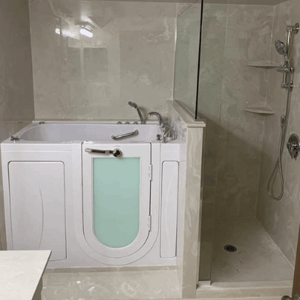 Walk In Tub Reviews Testimonials Feedback 17 White Ella walk-in tub with frosted door panel beside an accessible roll-in shower stall in a marble-tiled bathroom