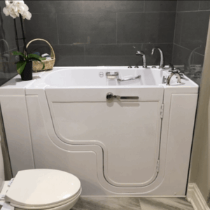 Walk In Tub Reviews Testimonials Feedback 29 White Ella walk-in tub with inward swing door installed in a modern gray tiled bathroom next to a toilet