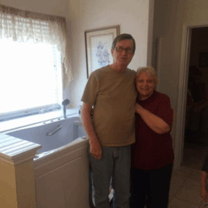 Walk In Tub Reviews Testimonials Feedback 31 Senior couple smiling together in their bathroom beside a newly installed Ella walk-in tub