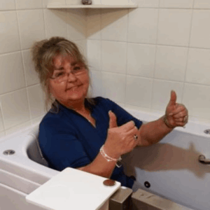 Walk In Tub Reviews Testimonials Feedback 43 Senior woman giving two thumbs up while seated inside her Ella walk-in bathtub showing satisfied customer approval