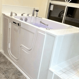 Walk In Tub Reviews Testimonials Feedback 55 White Ella walk-in tub with outward swing door, chrome faucets, and water jets filling the tub in a tiled bathroom