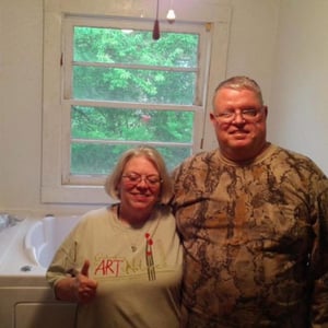 Walk In Tub Reviews Testimonials Feedback 8 Smiling couple standing in front of their newly installed Ella walk-in tub, sharing a positive review and testimonial