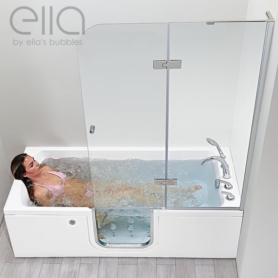 Mujer relajándose en una bañera de acceso reclinable de Ella con chorros de masaje de hidroterapia y mampara de ducha de cristal