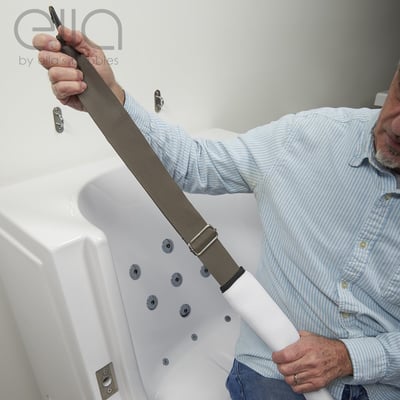 Senior man demonstrating an adjustable safety seat belt strap accessory for an Ella's Bubbles walk-in tub with hydrotherapy jets