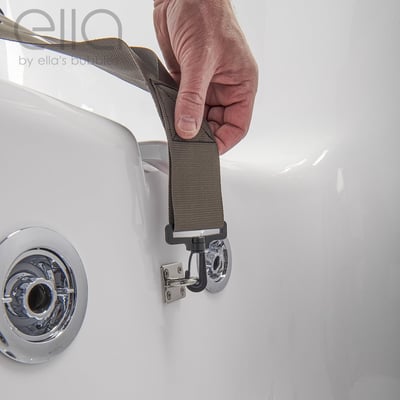 Close-up of a hand clipping a safety seat belt strap onto the chrome wall mount of an Ella walk-in tub