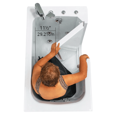Overhead view of a senior woman opening the Ella Flow walk-in tub door showing 11.5-inch wide entry clearance of 29.21cm