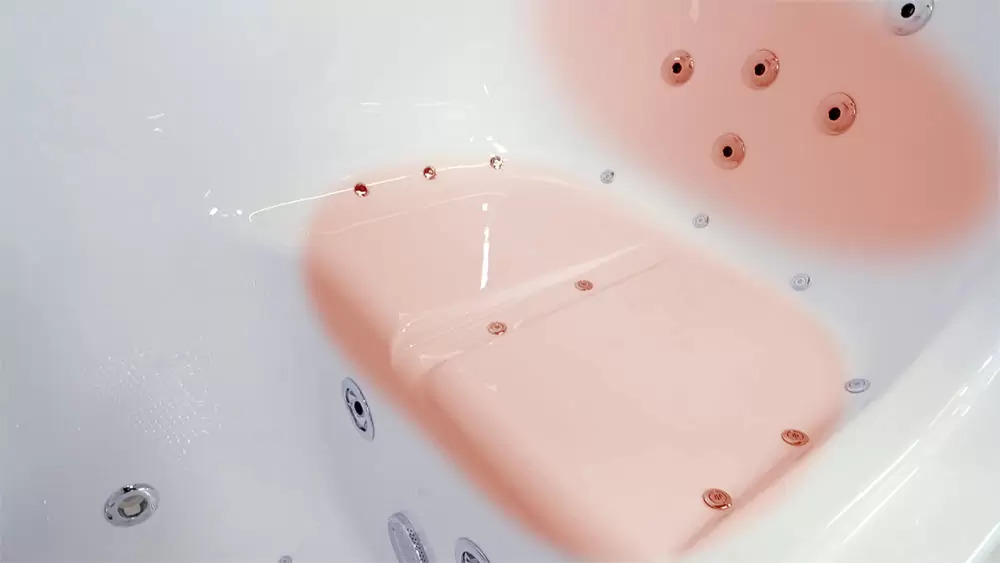 Zona del asiento y el respaldo con calefacción iluminada en el interior de una bañera con puerta Ella