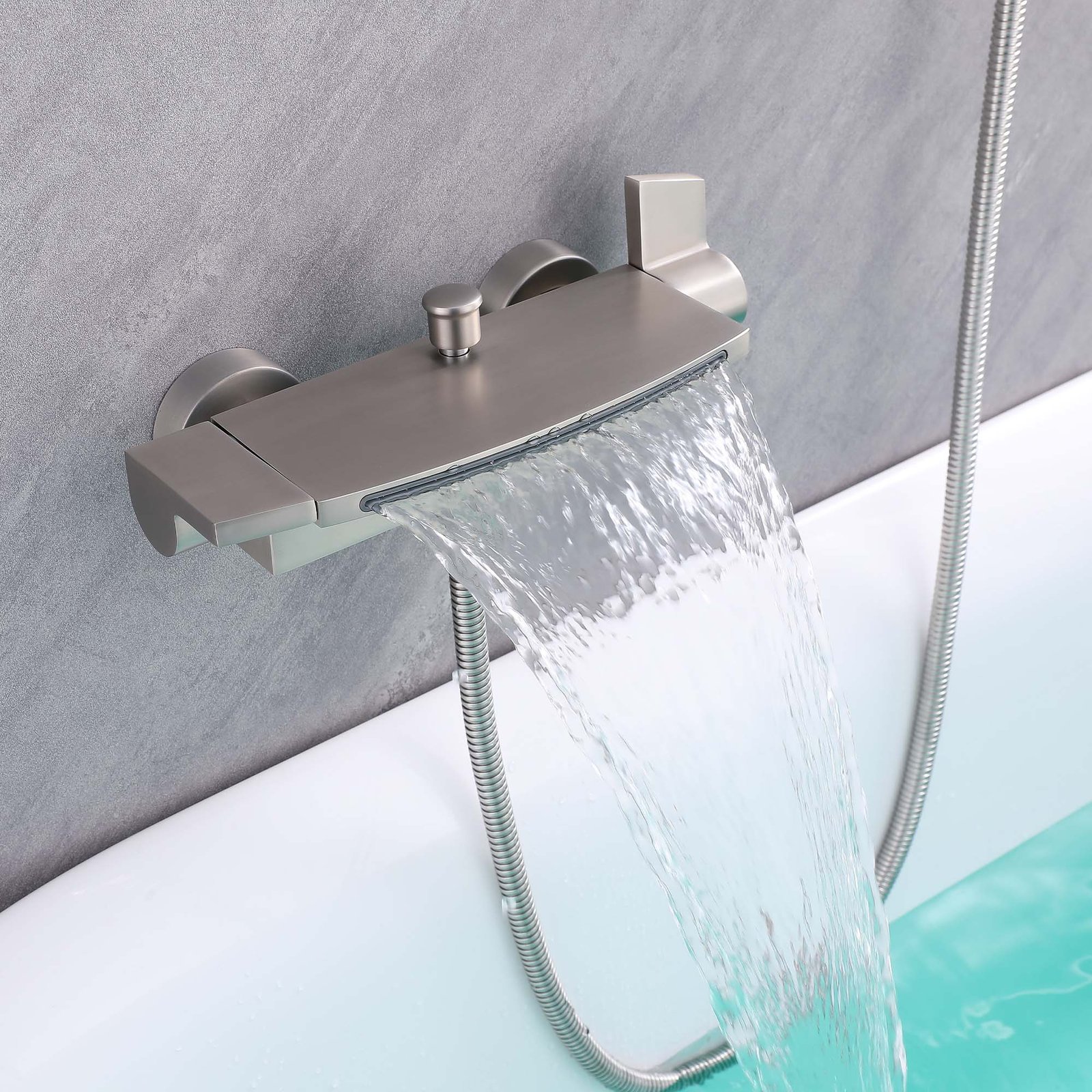 Brushed Thermostatic waterfall Faucet. Modern Wall-Mounted Mixer water Brushed nickel thermostatic waterfall faucet flowing water into a walk-in tub with handheld shower hose mounted on gray wall