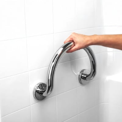 Hand gripping a polished stainless steel circle grab bar mounted on white tile in a walk-in tub bathing area
