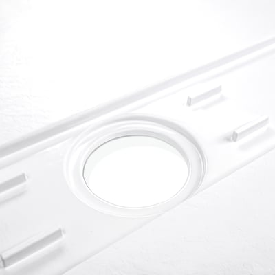 Gros plan d'une ouverture de bonde centrale d'un receveur de douche SMC ADA blanc conçu pour salles de bains accessibles