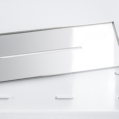 Gros plan sur une grille de caniveau linéaire en acier inoxydable pour un receveur de douche accessible en SMC conforme à l’ADA