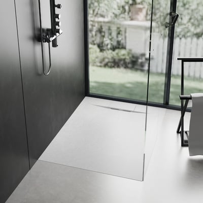 Zero-threshold white shower pan with linear drain and glass panel in a modern accessible roll-in shower stall